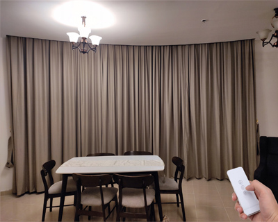 dining-room-with-full-wall-motorized-taupe-curtains-operated-by-white-remote-control